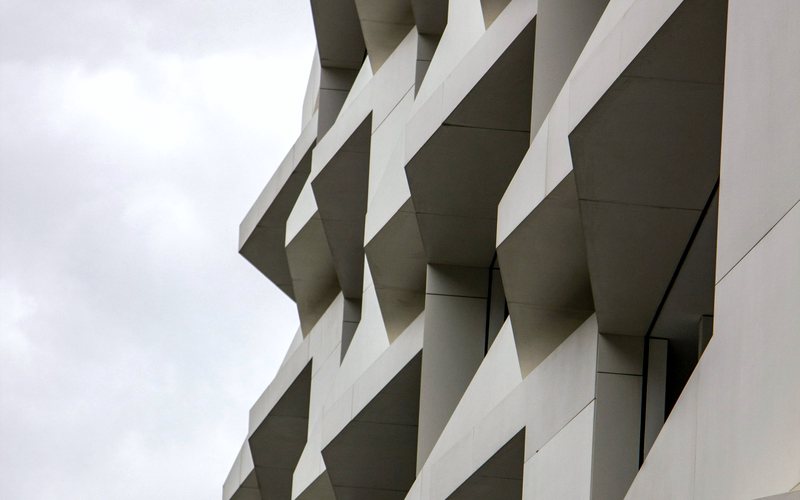 Concrete facade of stacked geometric panels.
